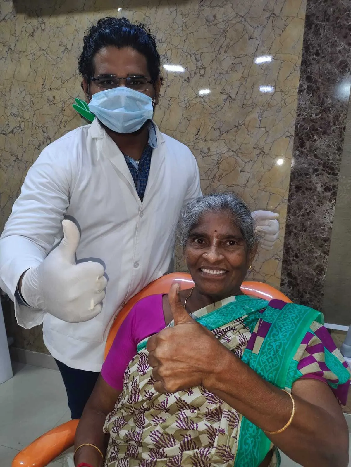 Dr. Ramakrishna Myla MDS smiling with happy elderly patient after successful smile restoration