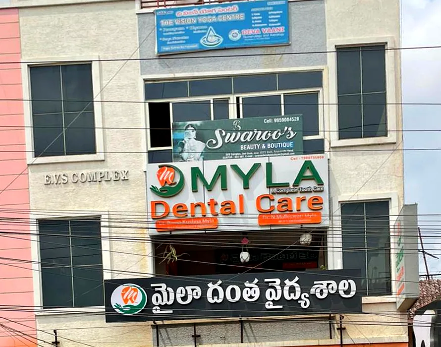 Focused exterior facade view of Myla Dental Care brand signage and Telugu signboard on Amaravathi Road