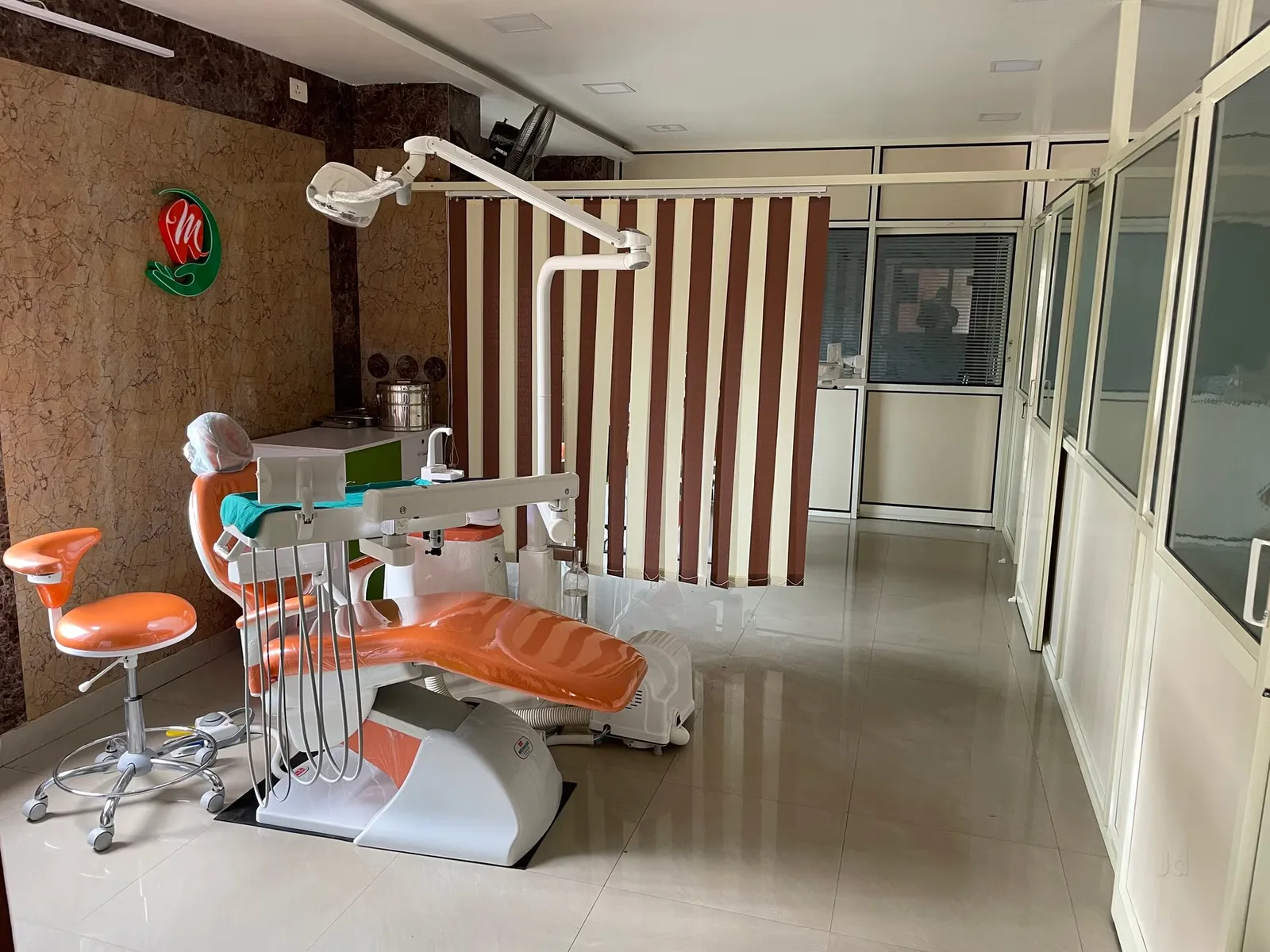 Hygienic dental operatory with privacy partition curtain and orange treatment chair