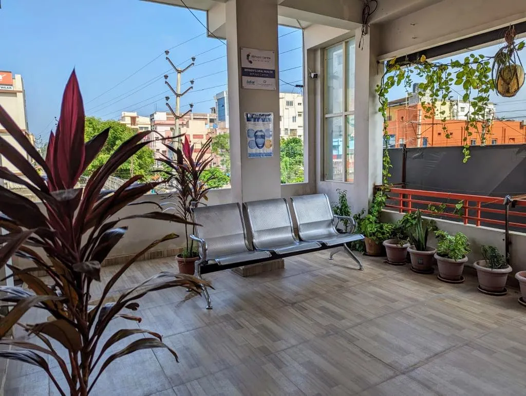 Open-air balcony waiting terrace with lush potted plants at Myla Dental Care Guntur